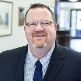 Picture of Jon Hobbs, AVP and Commercial Loan Officer smiling with the bank's lobby in the background